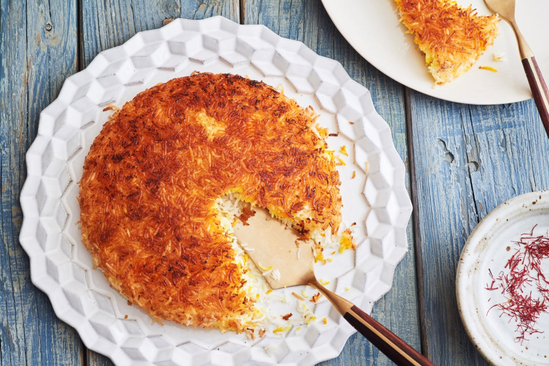 Crispy Rice (Tahdig) on a platter with a serving utensil and saffron